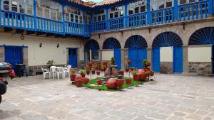 a building with blue doors and potted plants on a patio at Casa Grande Colonial Palace in Cusco