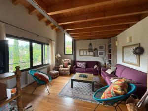 a living room with a purple couch and chairs at Villa La Pinpa in Bárcena de Cicero