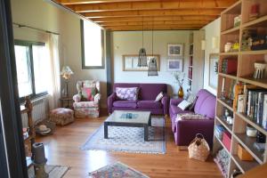 a living room with a purple couch and a table at Villa La Pinpa in Bárcena de Cicero