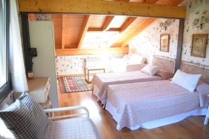 a bedroom with two beds in a room with wooden ceilings at Villa La Pinpa in Bárcena de Cicero +55 photos