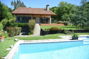 a house with a swimming pool in front of a house at Villa La Pinpa in Bárcena de Cicero