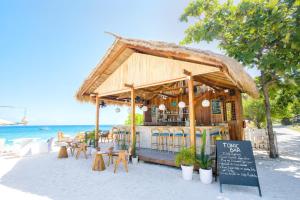 a bar on the beach with tables and chairs at MAHAMAYA Gili Meno in Gili Meno