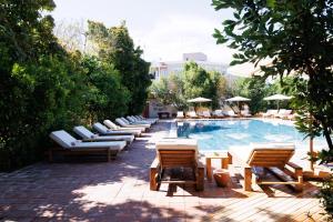 a row of chairs and tables next to a swimming pool at Lill Maison Hotel & City Club in Fethiye