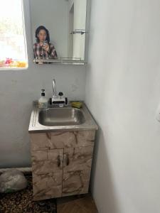 a woman taking a picture of a sink in a bathroom at Aimir in Akchiy