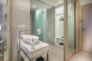 a bathroom with a shower, sink, and toilet at HARRIS Vertu Hotel Harmoni in Jakarta
