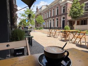 a cup of coffee sitting on top of a table at HotelBed w aircon at City Villa Tilburg Willem 1 in Tilburg