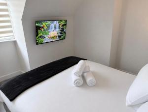 a bedroom with a bed with two rolled towels at Large 4-Bedrooms Corporate Flat, Free Parking - Amazing Location in Leavesden Green