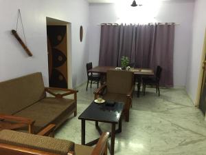 a living room with a couch and a table at Nalanda Tulip in Kolkata