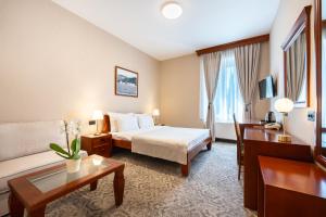 a hotel room with a bed and a couch at Hotel Montenegrino in Tivat
