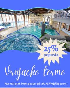 a large swimming pool in a building with a banner at Aura Apartmani Vrnjačka Banja in Vrnjci