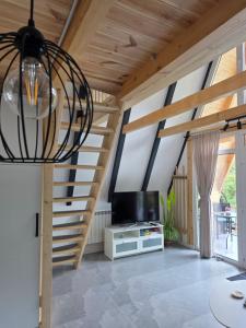 a living room with a spiral staircase and a television at REIA A-frame in Gura Râului