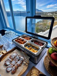 a buffet of food on a table with a view at Blu Rooms Santorini in Akrotiri