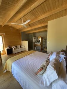 a woman laying on a large bed in a bedroom at Cabanas de Melides in Melides