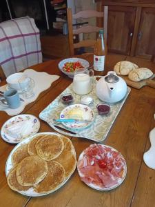 a wooden table with plates of food on it at Les Castelblotines in Châteaubleau
