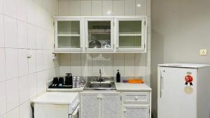 a kitchen with a sink and a white refrigerator at Al Raiyan Serviced Apartments in Taif +76 photos