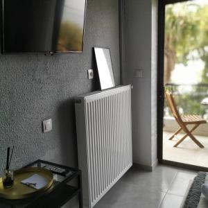 a living room with a radiator and a glass table at A. & C. Michailidi (Haris Mihailidis) in Neos Marmaras