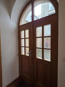 a wooden door in a room with a window at Apartmán Kräm in Klatovy