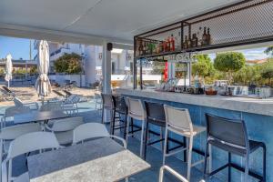 a restaurant with tables and chairs and a bar at Naiades Hotel by Estia in Kato Gouves
