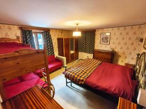 a bedroom with a red bed and a red couch at Alma Hunting Lodge in Borca di Cadore
