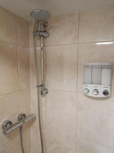a shower with a shower head in a bathroom at The Loy Guest Apartment in Cookstown