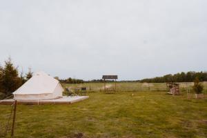 a white tent in a field with a basketball hoop at Mardi talu Glamping in Paekna