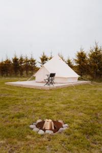 a tent in a field with a chair in the grass at Mardi talu Glamping in Paekna