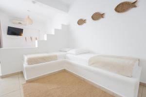 a white bed in a white room with white walls at Harmony Hotel in Sarandë