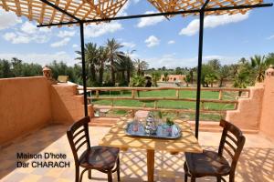 a table and chairs on a patio with a view at Maison d hôtes Dar Charach in Ouarzazate