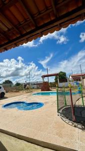 a playground with a pool and a person riding a horse at Chácara Marias Da Serra in Araruna