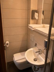 a bathroom with a sink and a toilet and a mirror at Hotel Pasa Paradies KOSTENLOSE PARKPLÄTZE in Hanau am Main