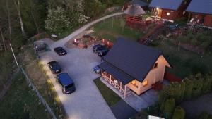 an overhead view of a house with cars parked in a parking lot at Domek u Pusi z jacuzzi in Solina