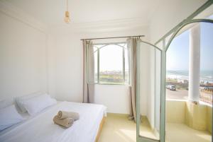 a bedroom with a bed and a large window at Sand House in Imsouane
