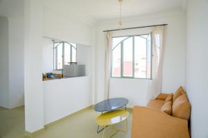 a living room with a couch and a table and a window at Sand House in Imsouane