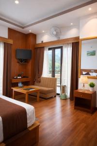 ein Hotelzimmer mit einem Bett und einer Couch in der Unterkunft Hotel HTC , Thimphu in Thimphu
