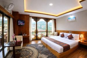 ein Hotelzimmer mit Bett, Schreibtisch und Fenster in der Unterkunft Hotel HTC , Thimphu in Thimphu