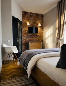 a bedroom with a bed and a brick wall at LVIV -APART центр 2 кім ізольовані і кухня студія in Lviv