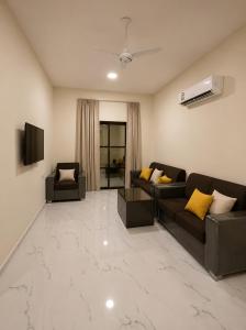 a living room with two couches and a television at RED Gardenia in Salalah