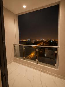 a balcony with a view of a city at night at RED Gardenia in Salalah