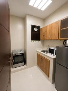 a small kitchen with a sink and a refrigerator at RED Gardenia in Salalah