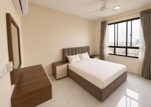 a bedroom with a bed and a large window at RED Gardenia in Salalah