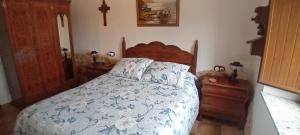 a bedroom with a bed and a cross on the wall at Stone Cottage FISTERRA in Curtis