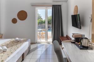 a hotel room with a bed and a table and a view at Naiades Hotel by Estia in Kato Gouves +33 photos