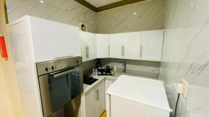 a white kitchen with white cabinets and a refrigerator at Al Raiyan Serviced Apartments in Taif