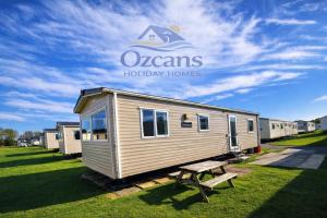 a tiny house with a bench in front of it at Luxury 3 Bedroom Caravan Near Edinburgh in Port Seton
