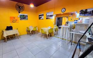 a restaurant with yellow walls and tables and chairs at Hotel Internacional in Tacuarembó