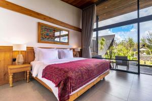 a bedroom with a large bed and a large window at Anandinii Resort Sidemen by AGATA in Sidemen