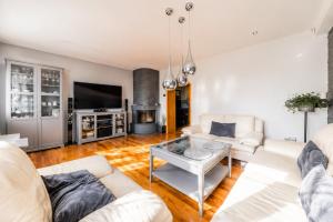 a living room with white furniture and a fireplace at Villa Aqua Wągrowiec Pool House in Wągrowiec
