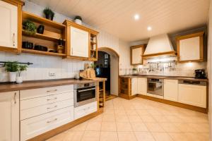 a large kitchen with wooden cabinets and white appliances at Villa Aqua Wągrowiec Pool House in Wągrowiec
