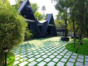 a house with a geometric roof and a garden at Creek Cottage in Kollam
