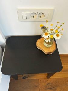 a vase of flowers on a black table at Barn House in Ptuj
